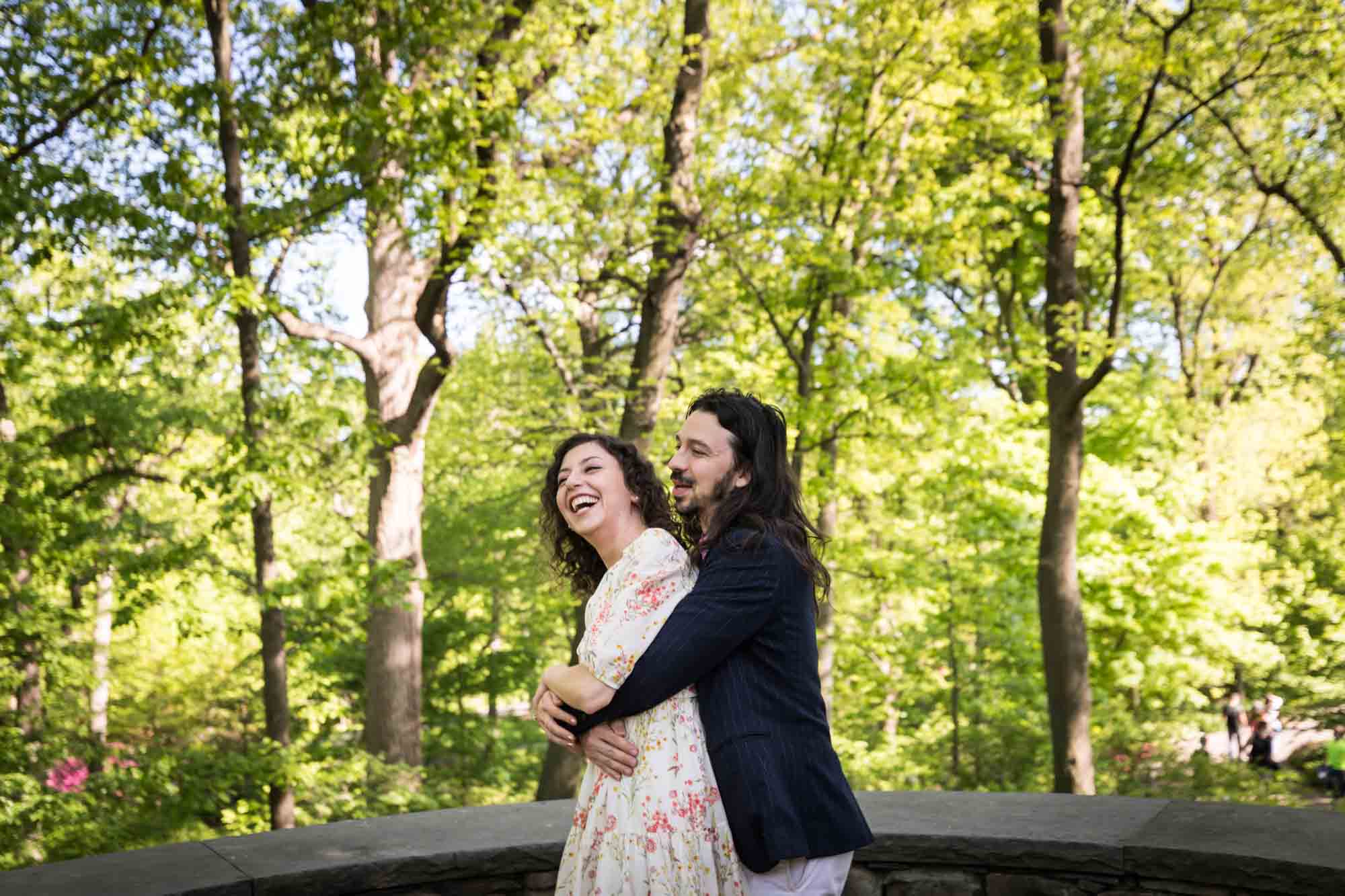 New York Botanical Garden engagement photos of couple hugging in front of trees