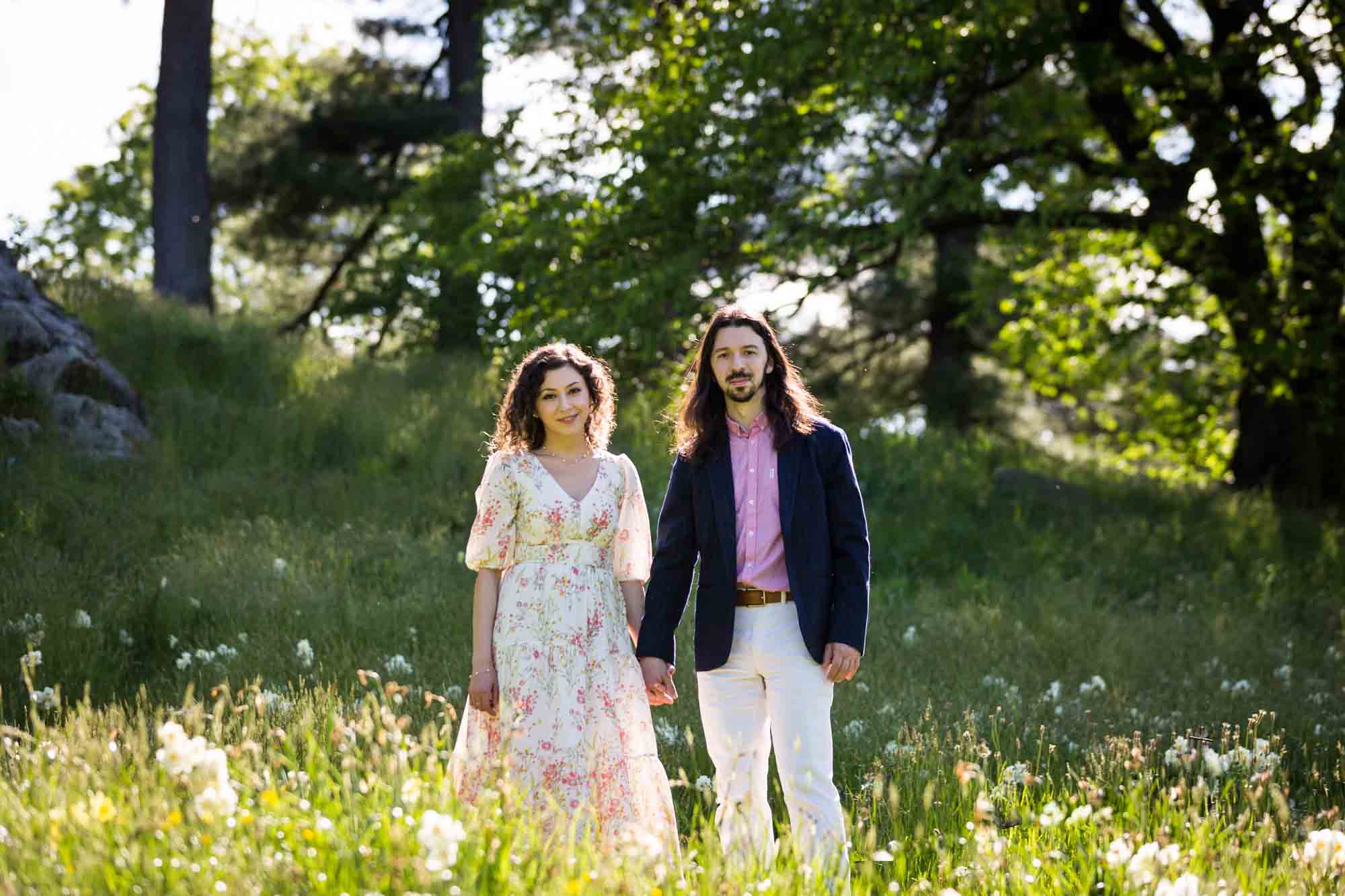 Couple standing in meadow holding hands in the New York Botanical Garden