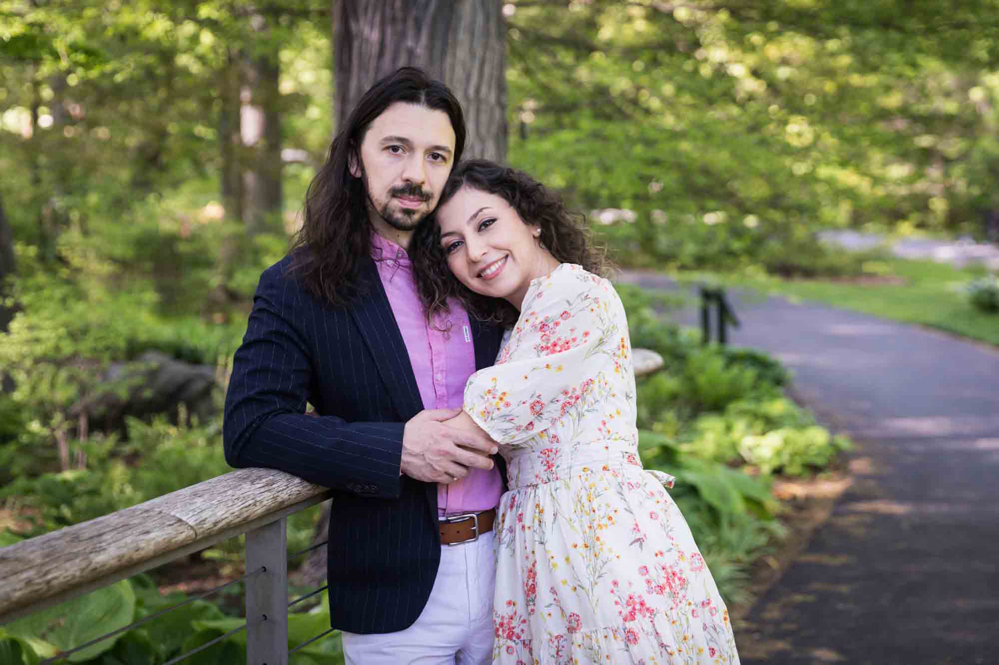Couple hugging on bridge in New York Botanical Garden