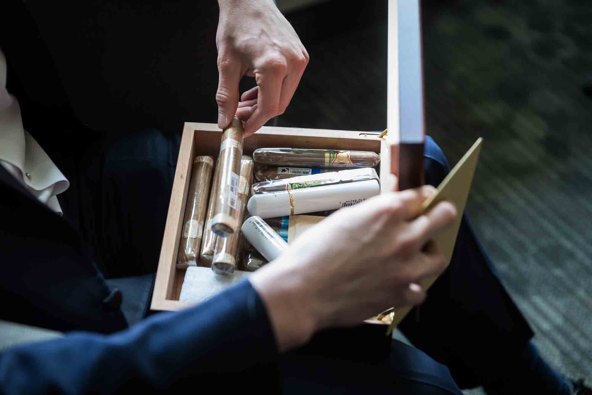 Hand of groom opening container with cigars