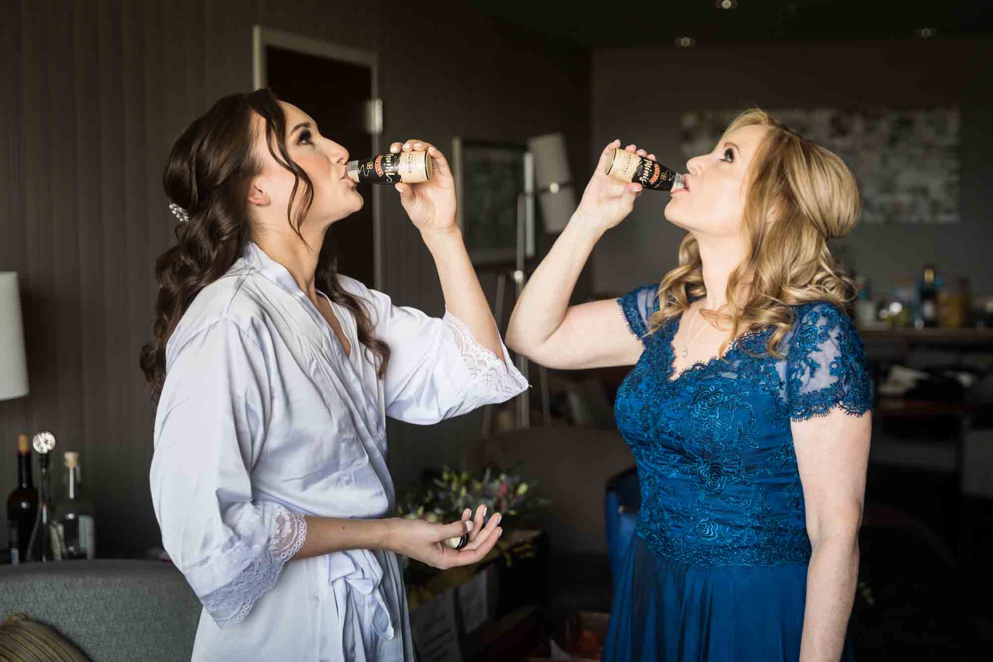 Bride and mother drinking from small bottles