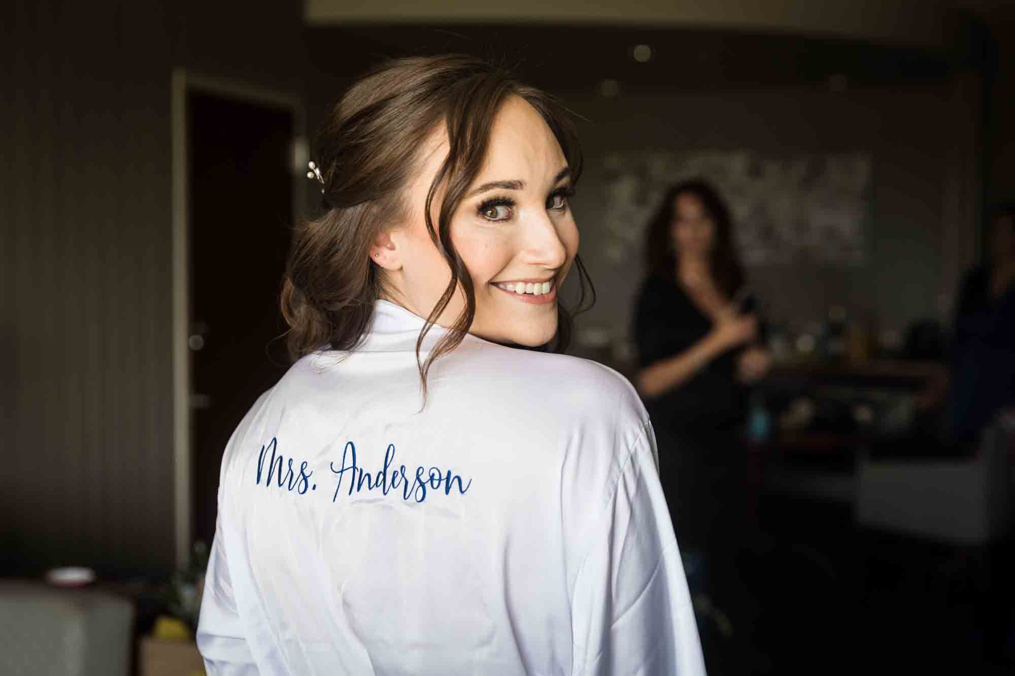 Bride wearing robe and looking over shoulder