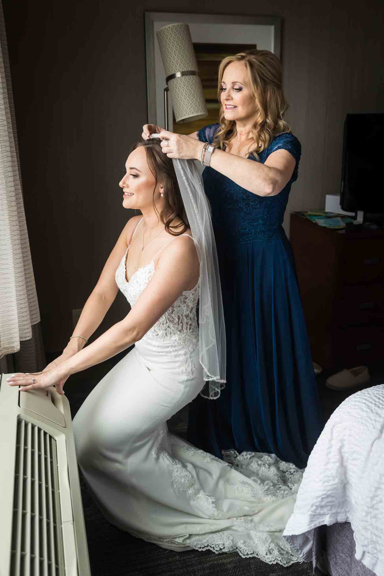 Mother putting veil in bride's hair