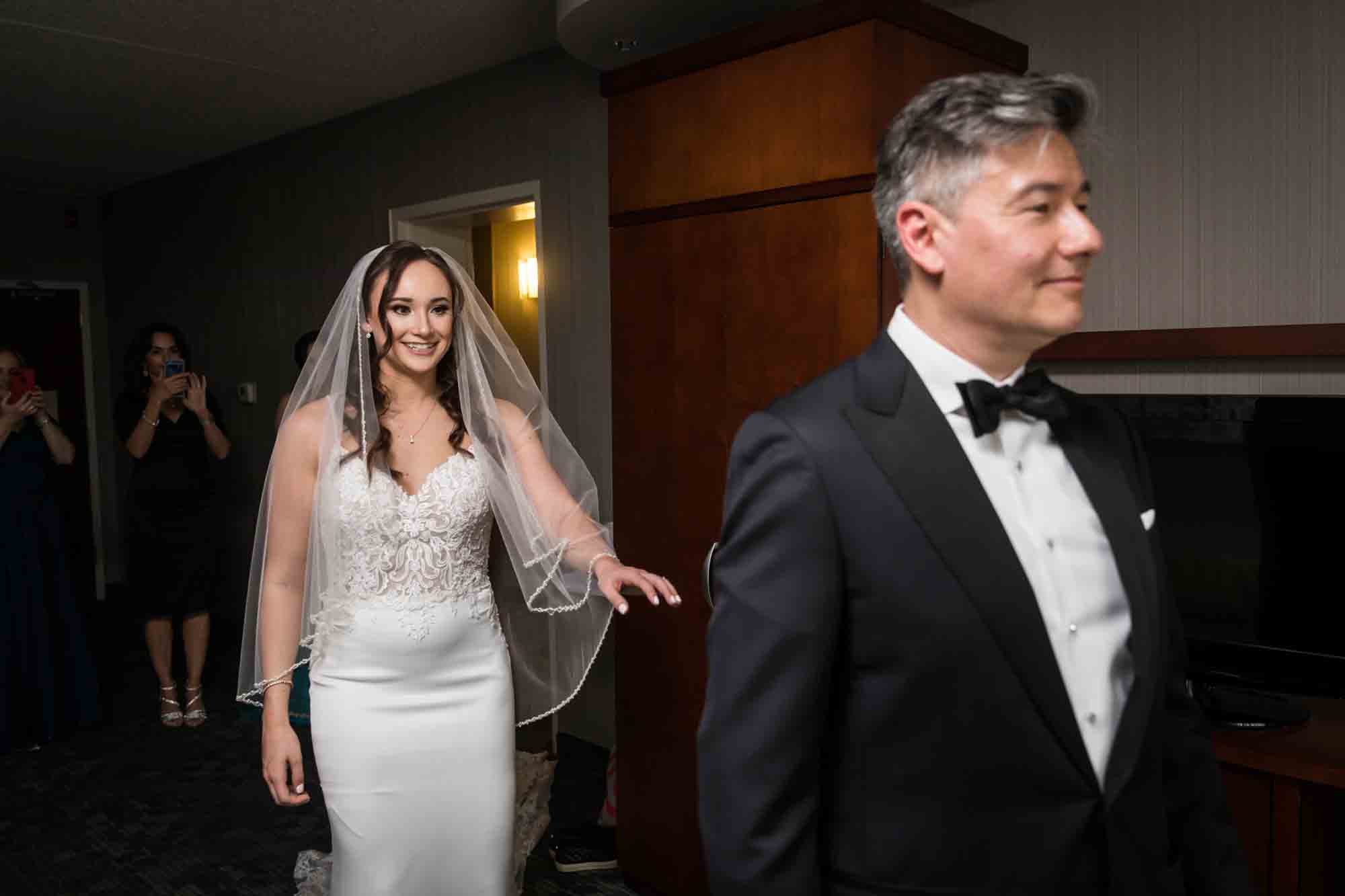 Bride walking up behind father with hand extended