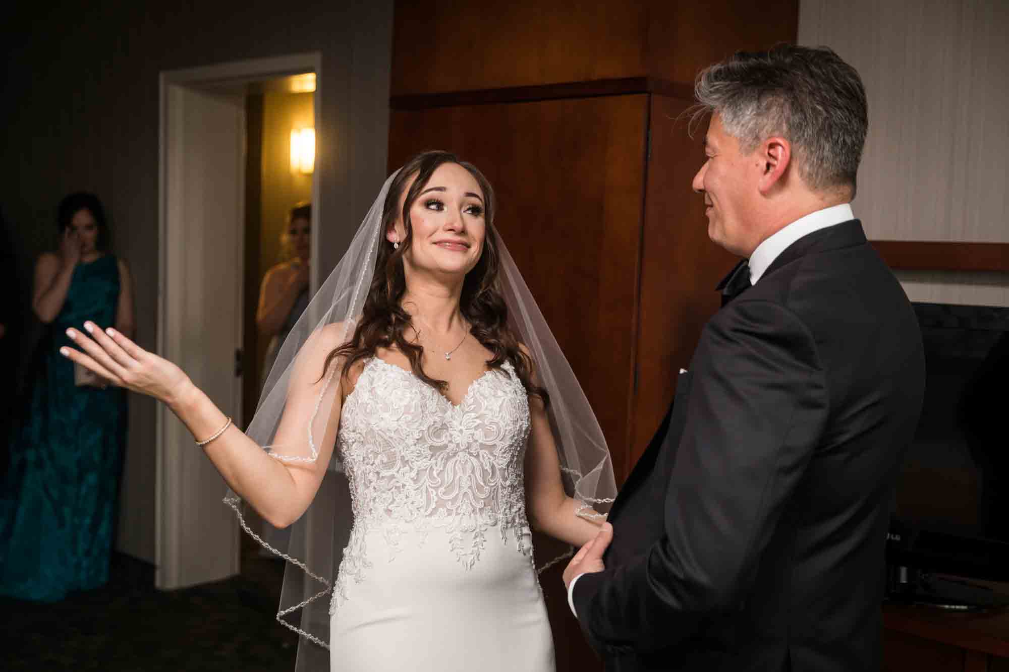 Bride with hand up talking to father