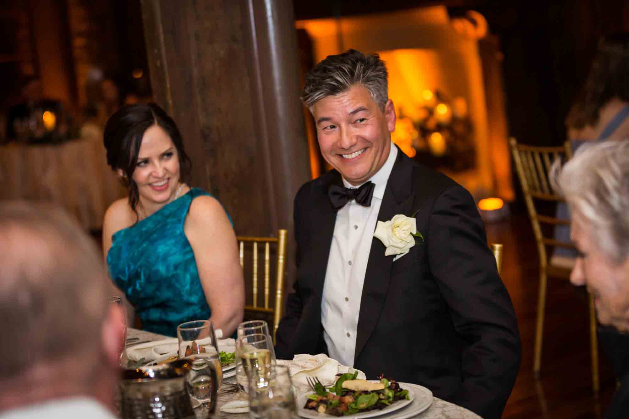 Couple sitting at table enjoying reception at Riviera Waterfront Mansion wedding