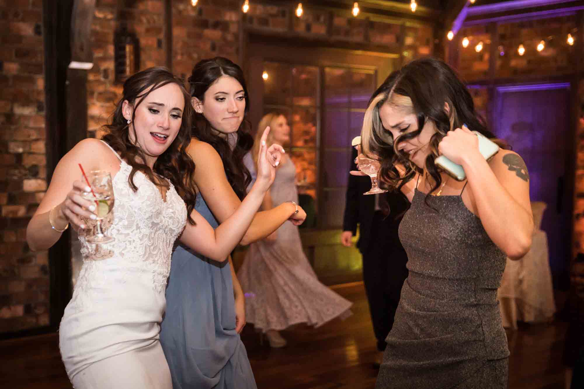 Bride and female guests dancing at Riviera Waterfront Mansion wedding