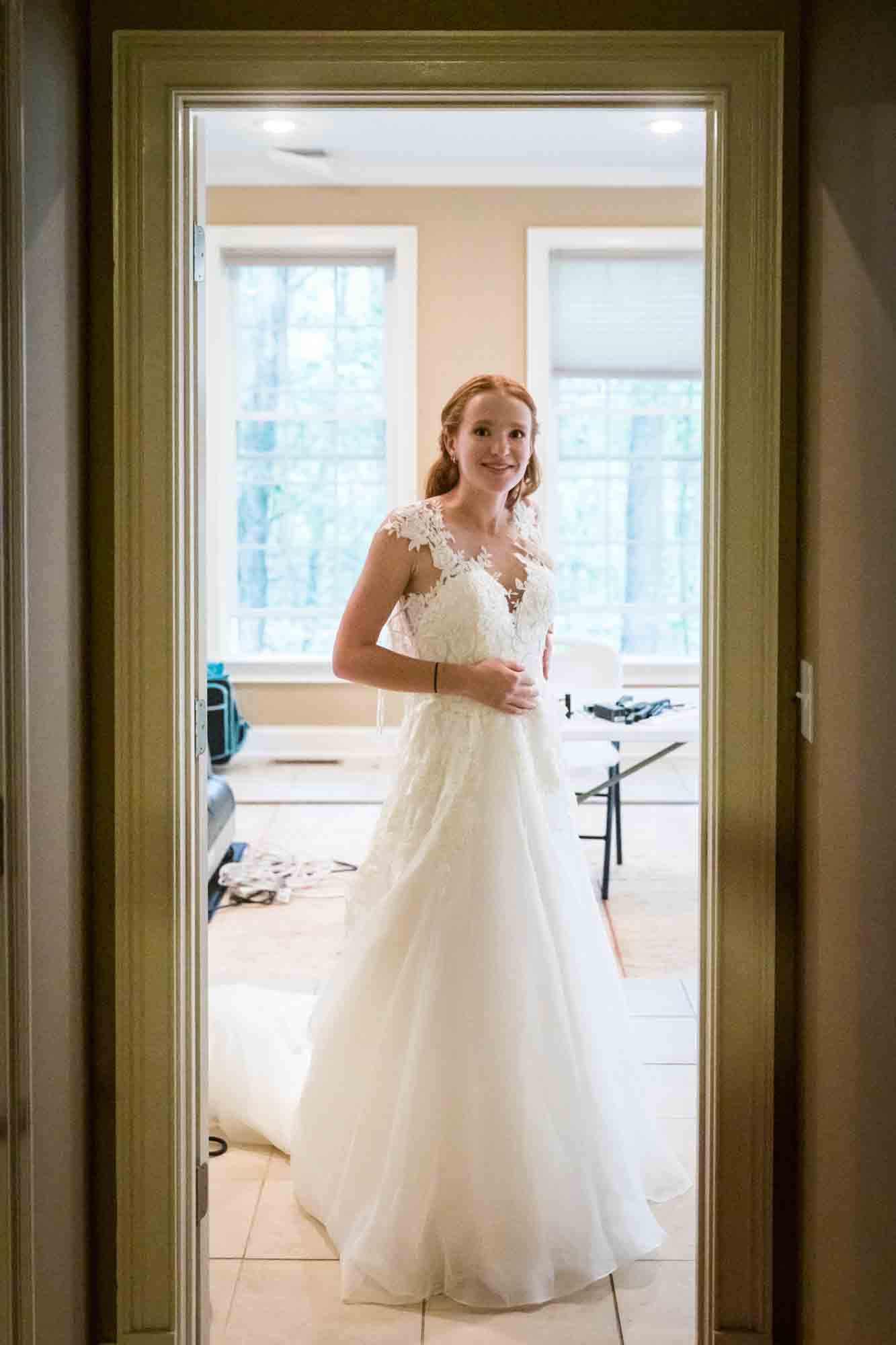 Bride wearing wedding dress in doorway