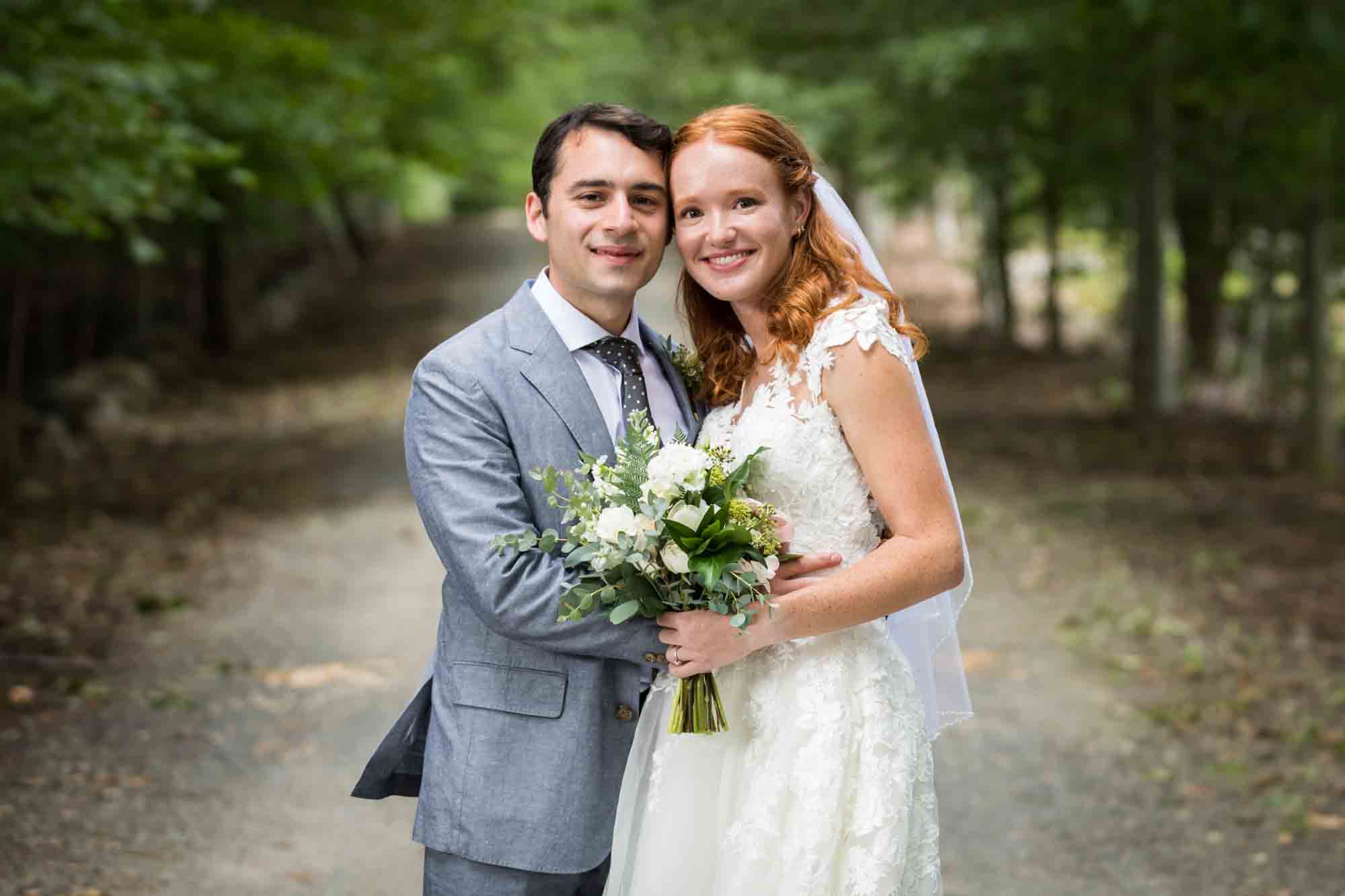 Bride and groom holding bouquet in driveway for an article on backyard wedding tips