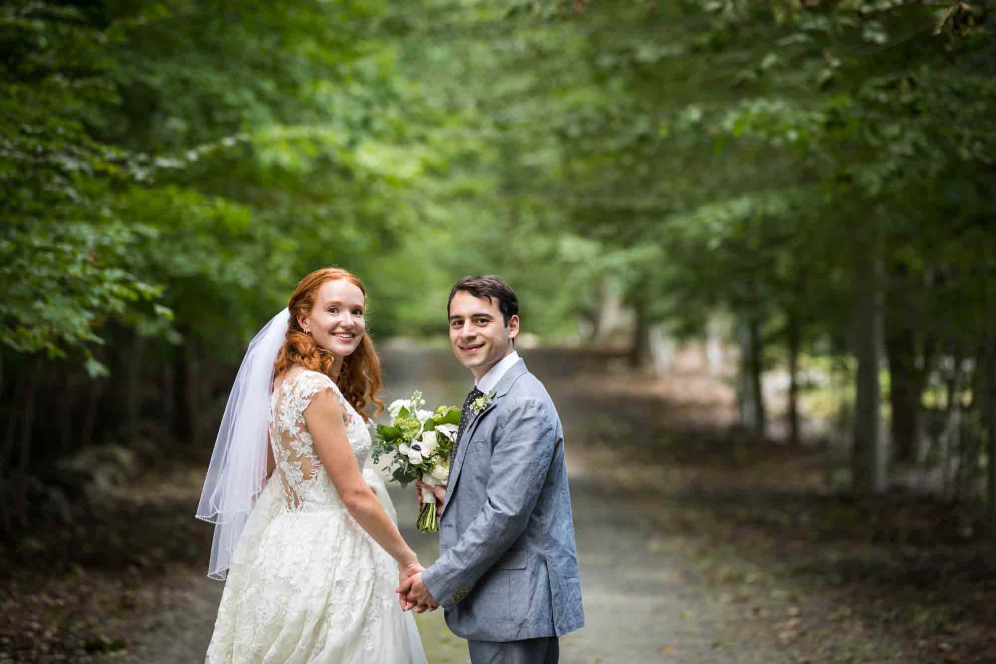 Bride and groom holding hands in middle of driveway for an article on backyard wedding tips