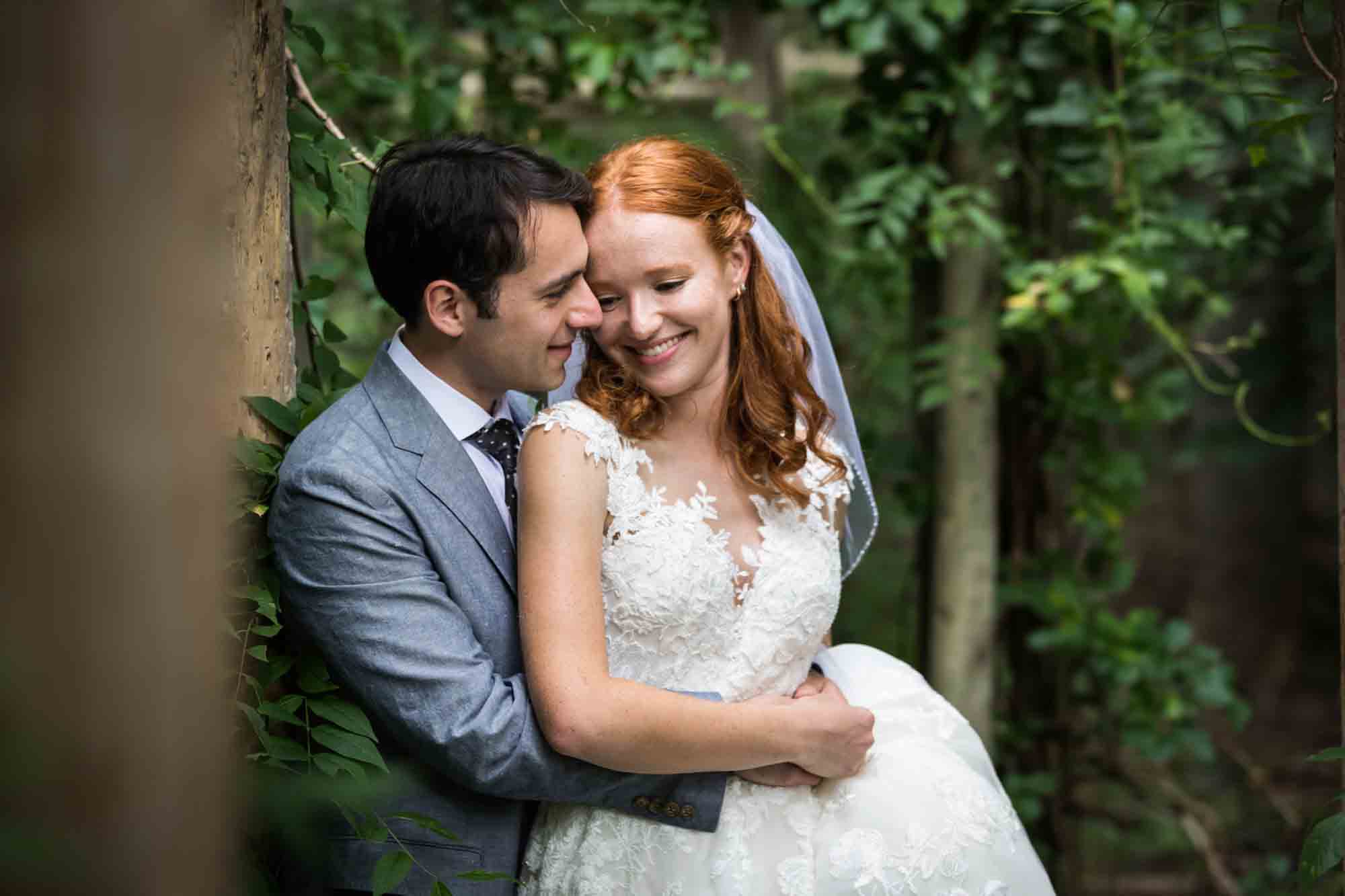 Bride and groom hugging in forest for an article on backyard wedding tips
