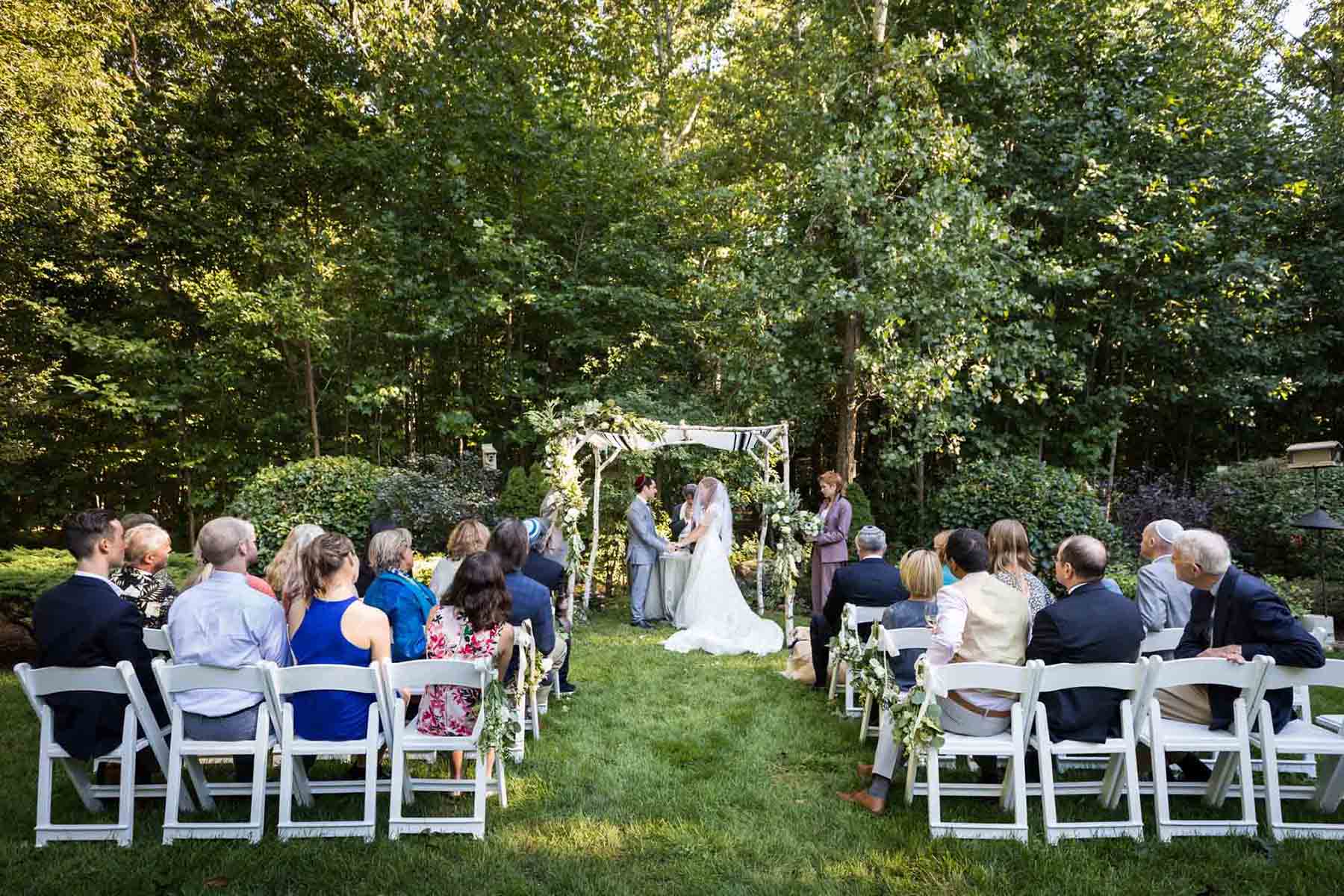 Wedding ceremony in backyard with chuppah for an article on backyard wedding tips