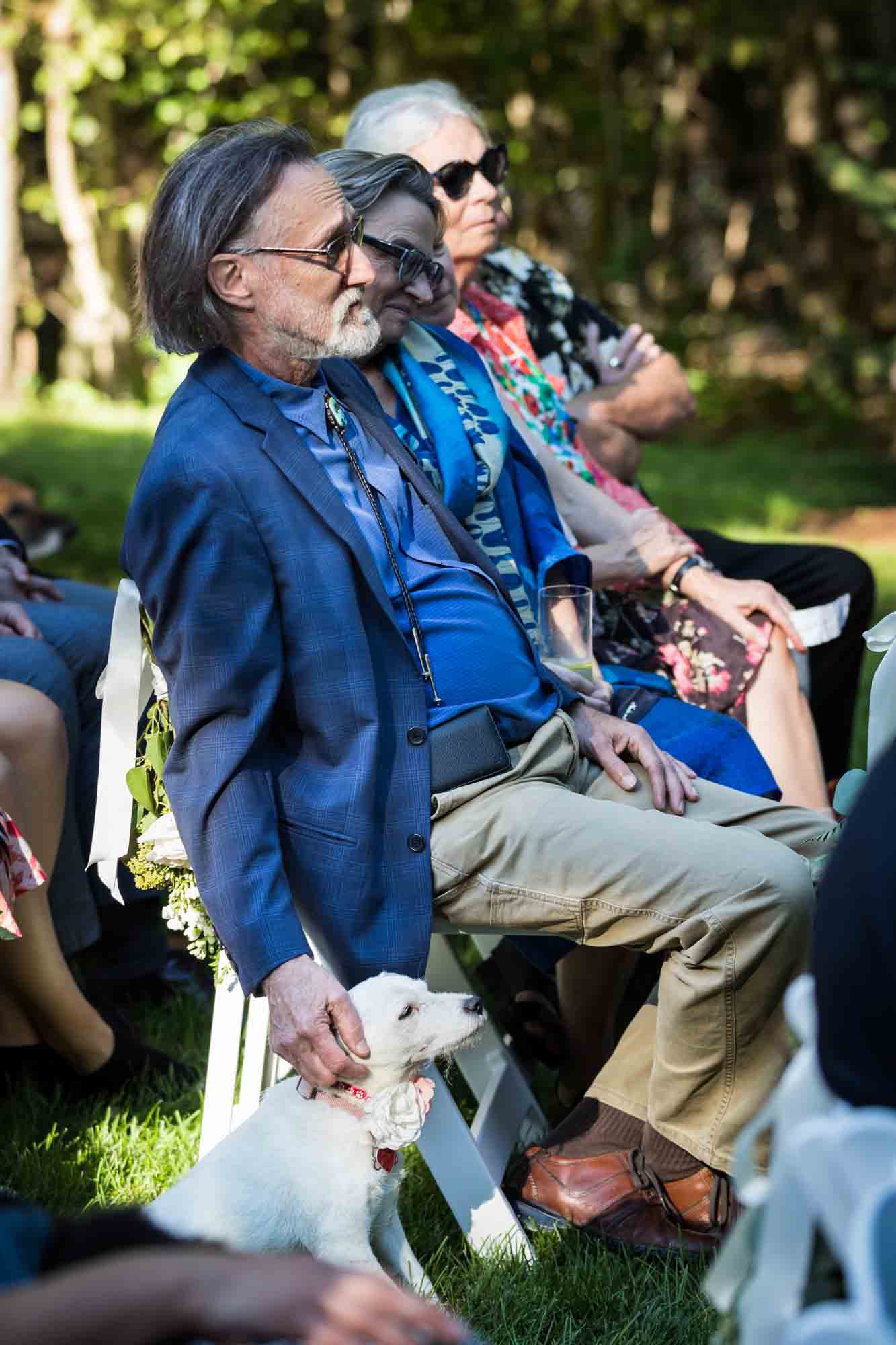 Guest petting dog during wedding ceremony