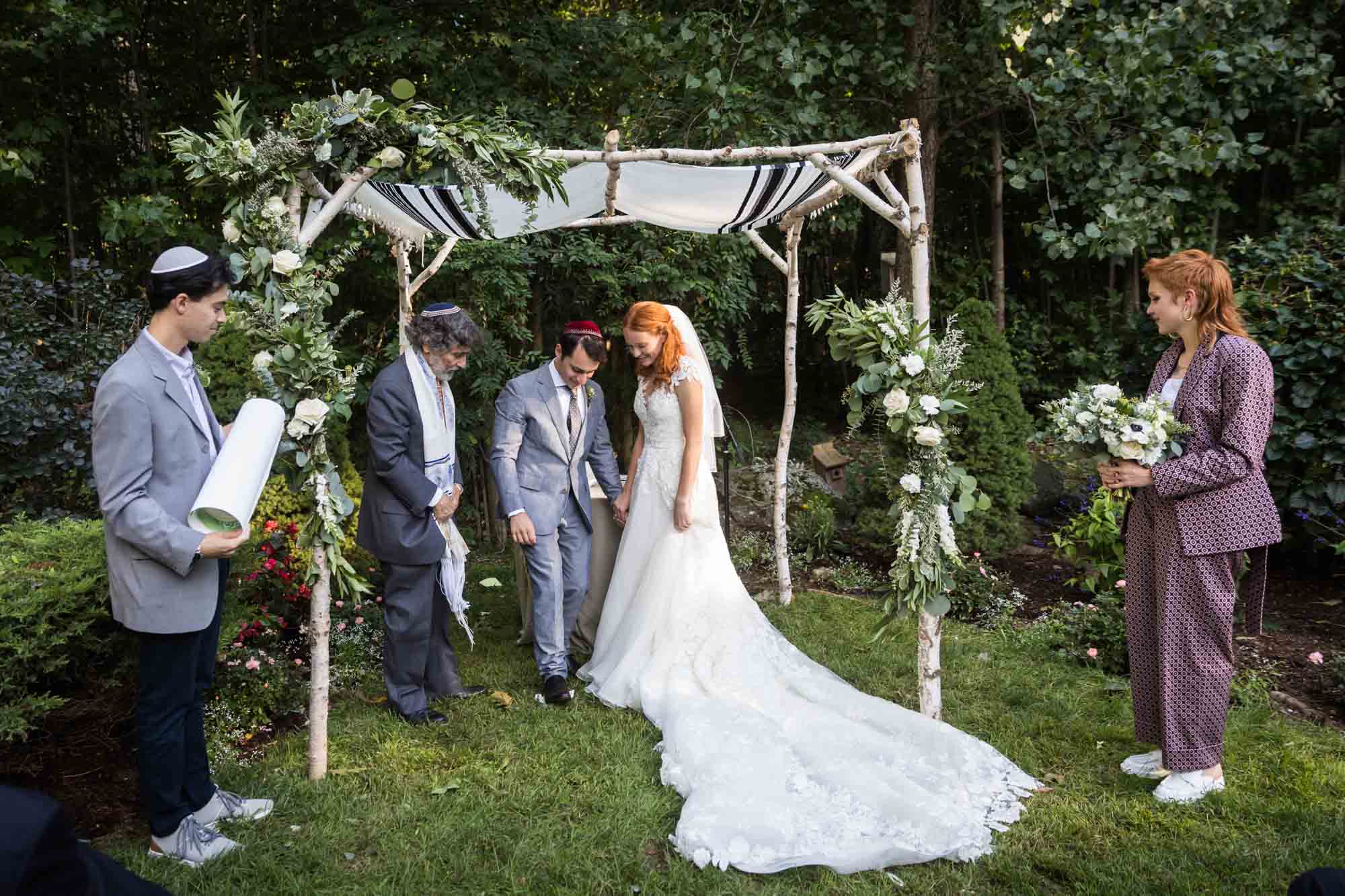 Groom breaking glass with bride during ceremony