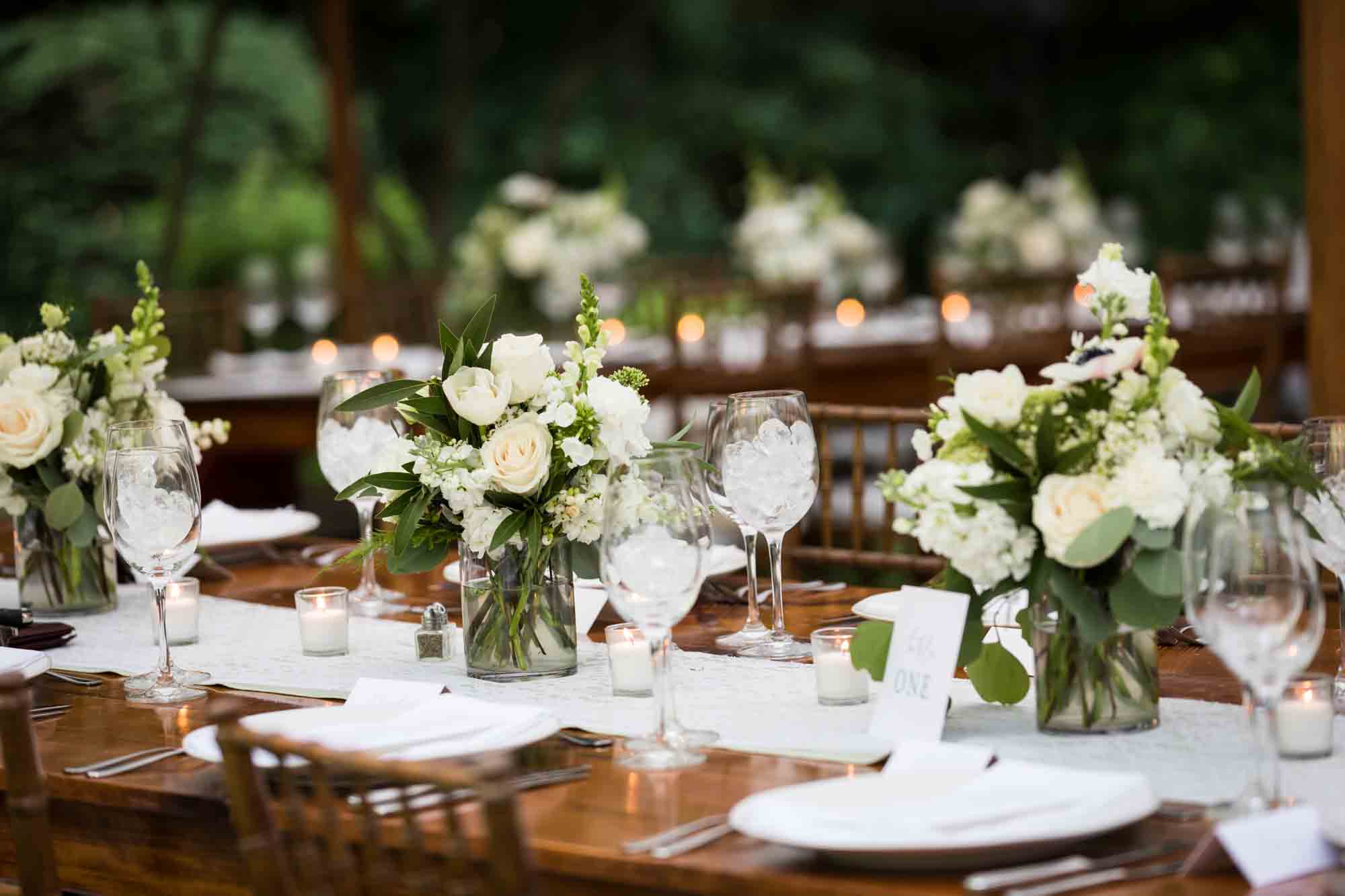 Table set with white flower bouquets for an article on backyard wedding tips