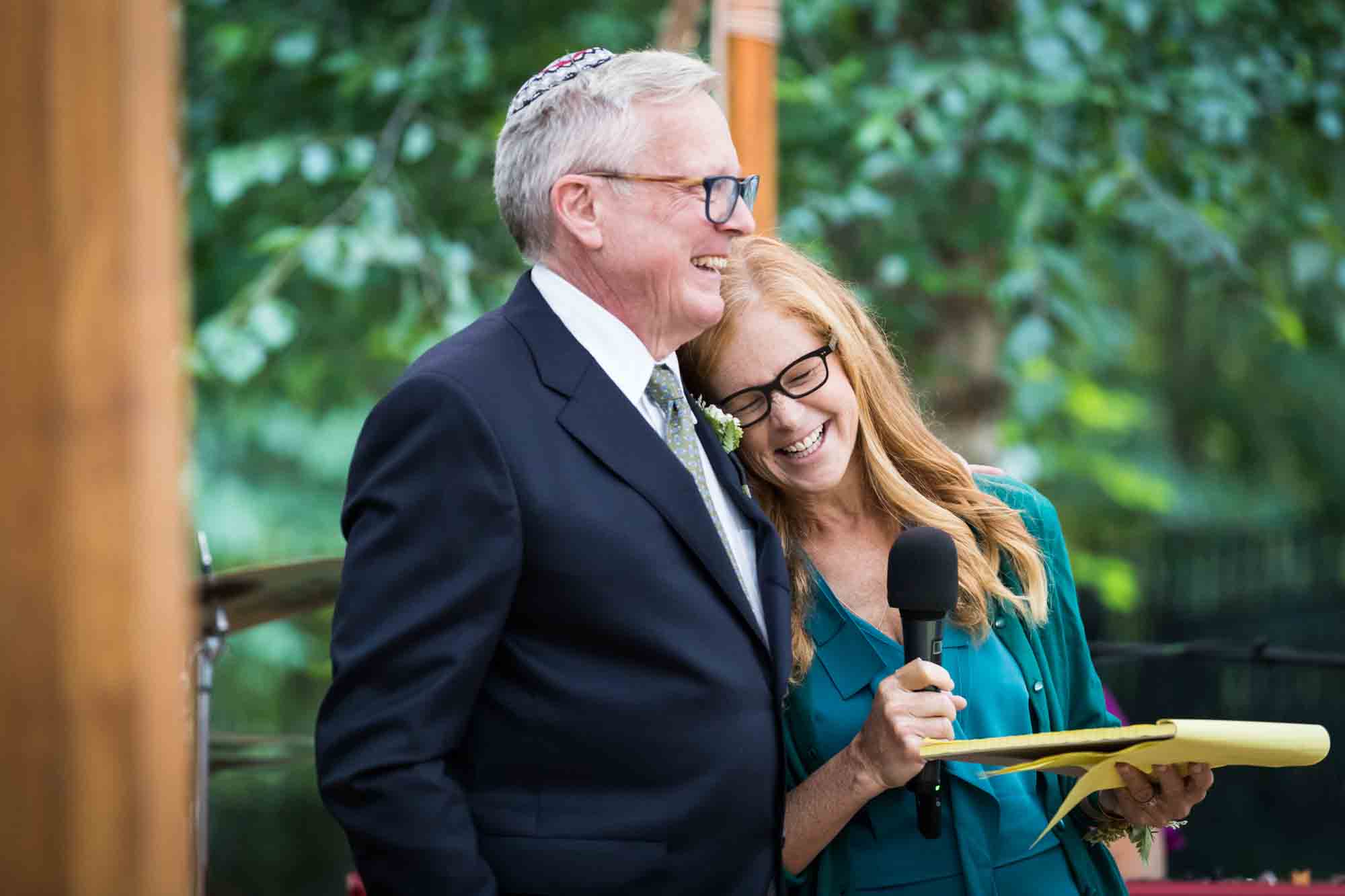 Man and woman hugging during speeches for an article on backyard wedding tips