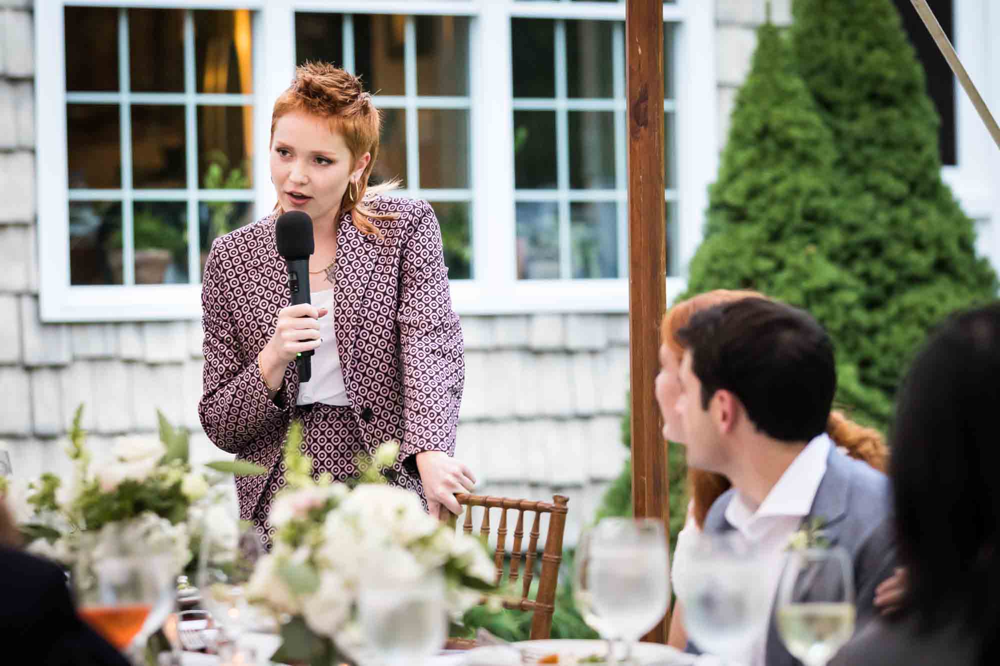 Woman with red hair talking into a microphone for an article on backyard wedding tips