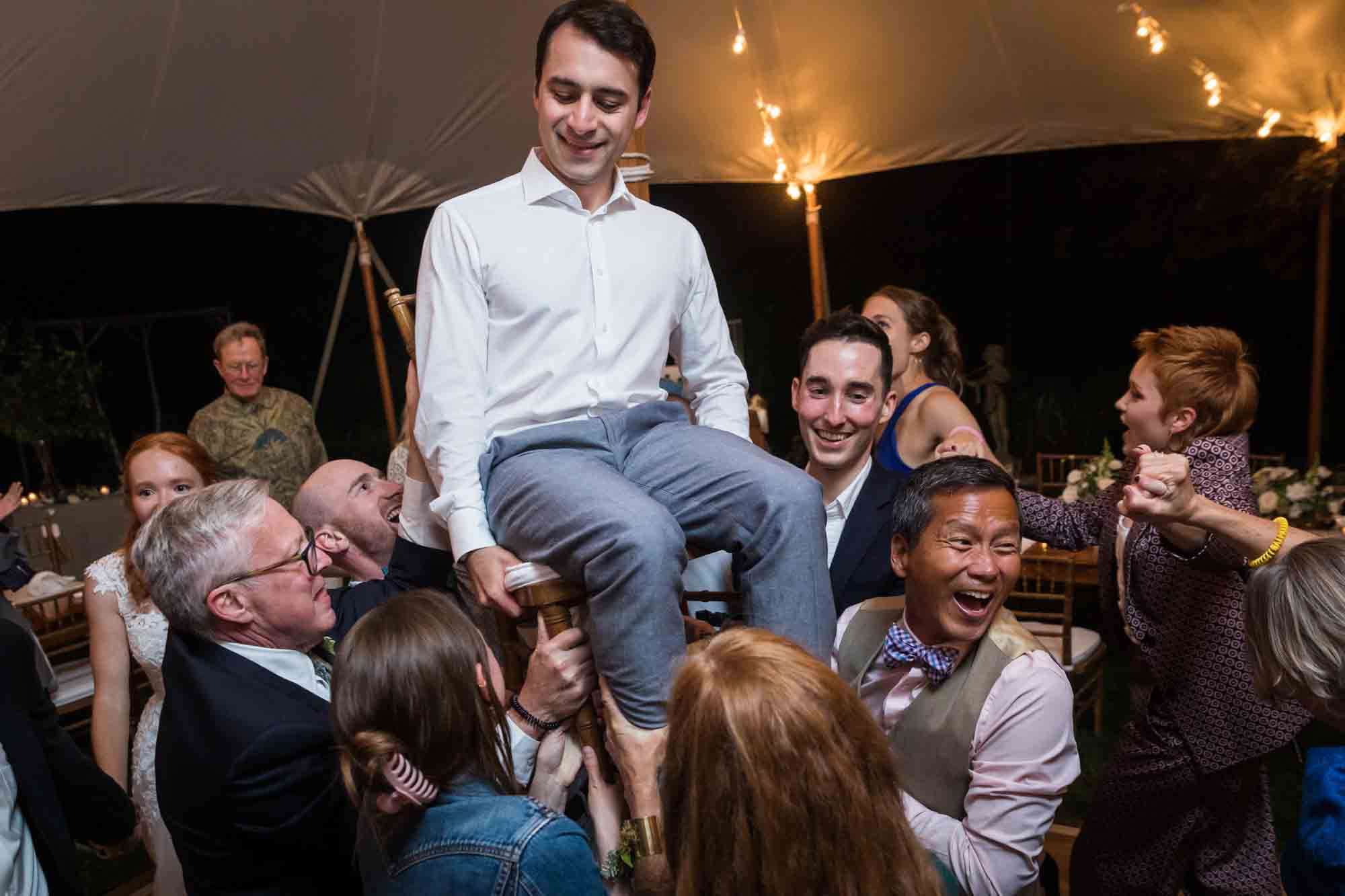 Groom lifted on chair during hora dance