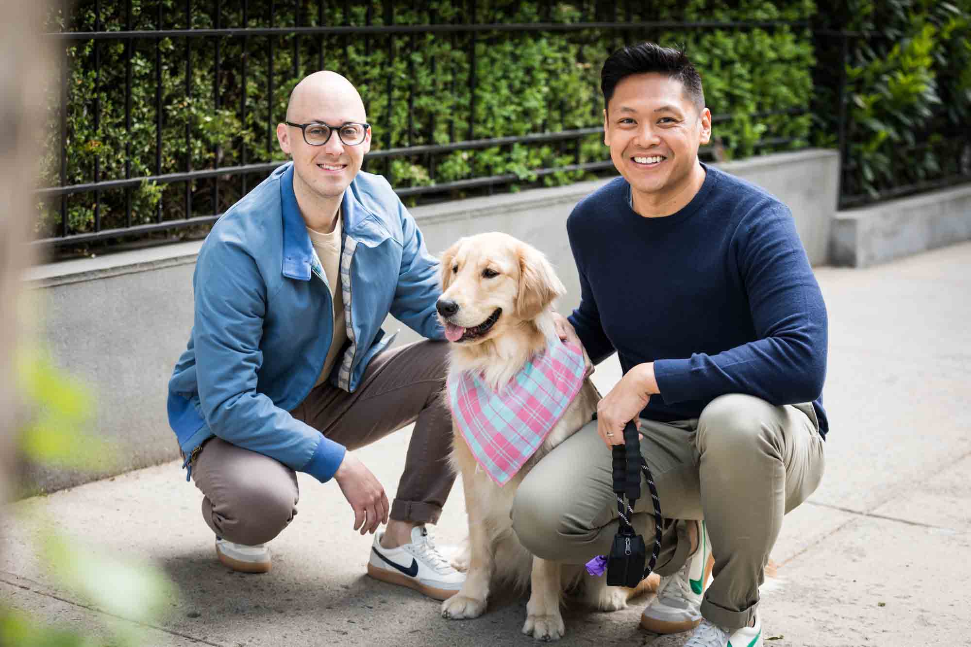 Two men squatting beside a golden retriever from a Central Park engagement photo shoot
