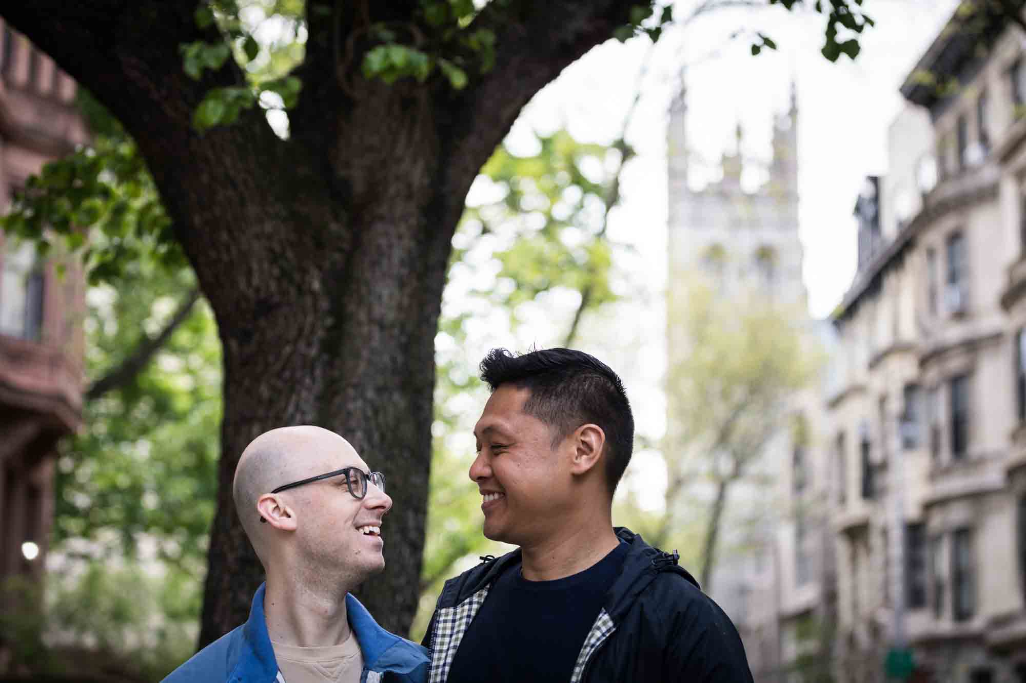 Two men looking at each other with church tower in background
