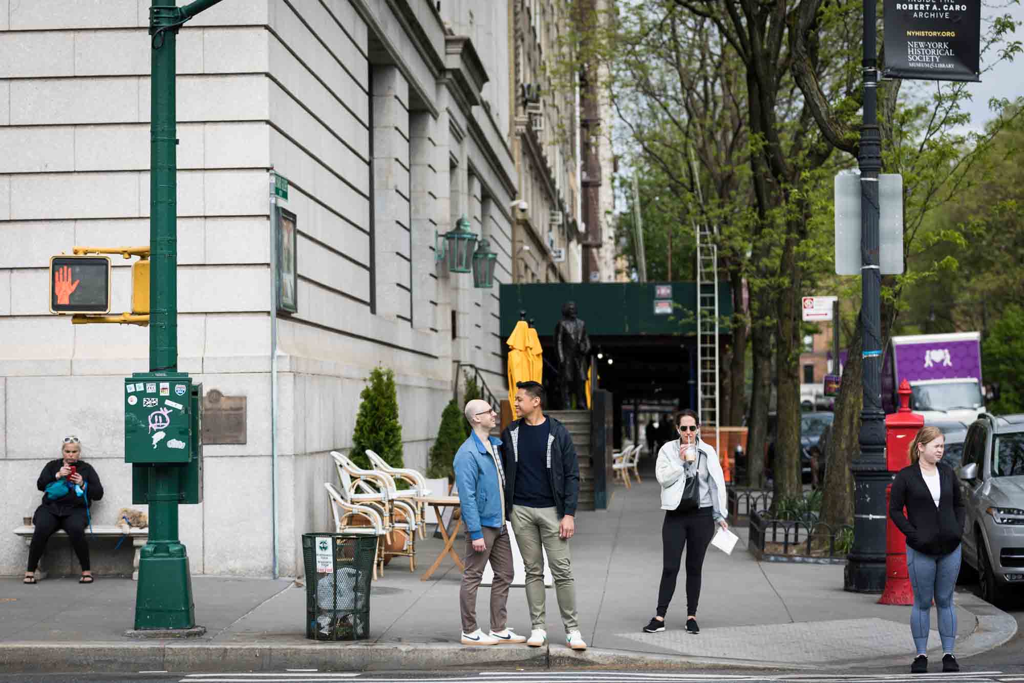 Two men standing on corner of NYC sidewalk