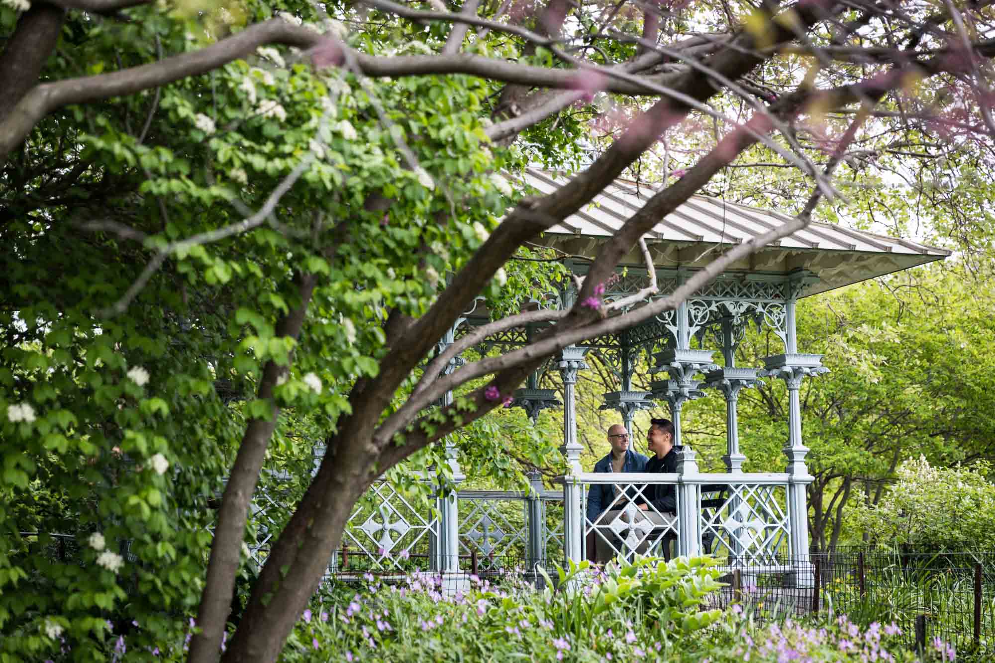 Two men sitting inside Ladies Pavilion in Central Park