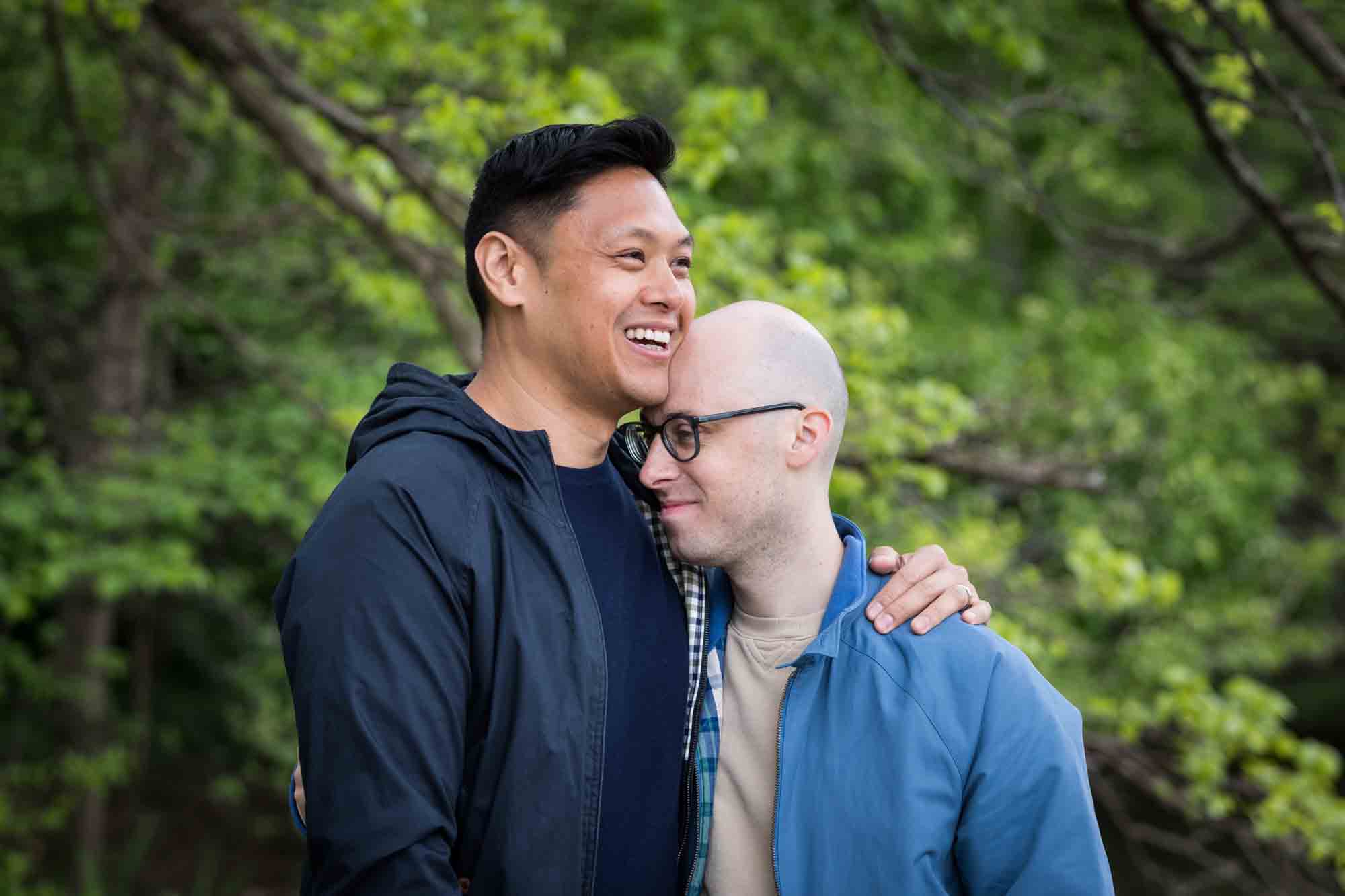 Two men in front of trees from a Central Park engagement photo shoot