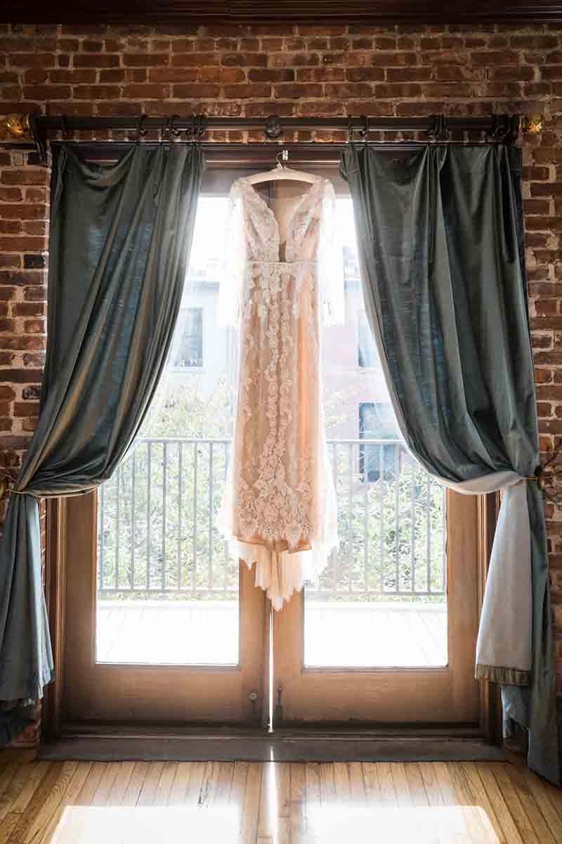 Wedding dress hanging in front of French doors