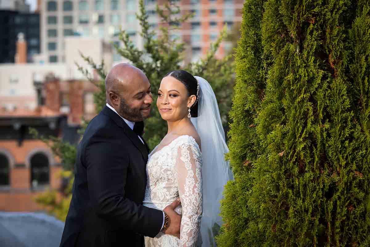 Deity wedding photos of bride and groom beside bush on roof