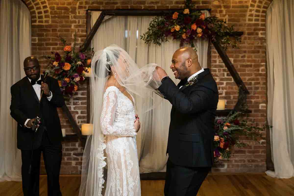 Groom lifting bride's veil at a Deity wedding