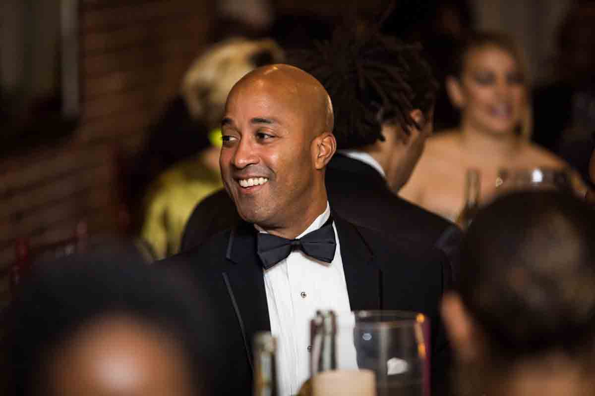 African American guest smiling and wearing tuxedo at a Deity wedding