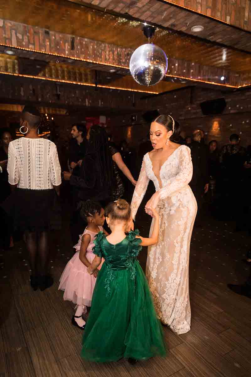 Bride dancing with two little girls at a Deity wedding
