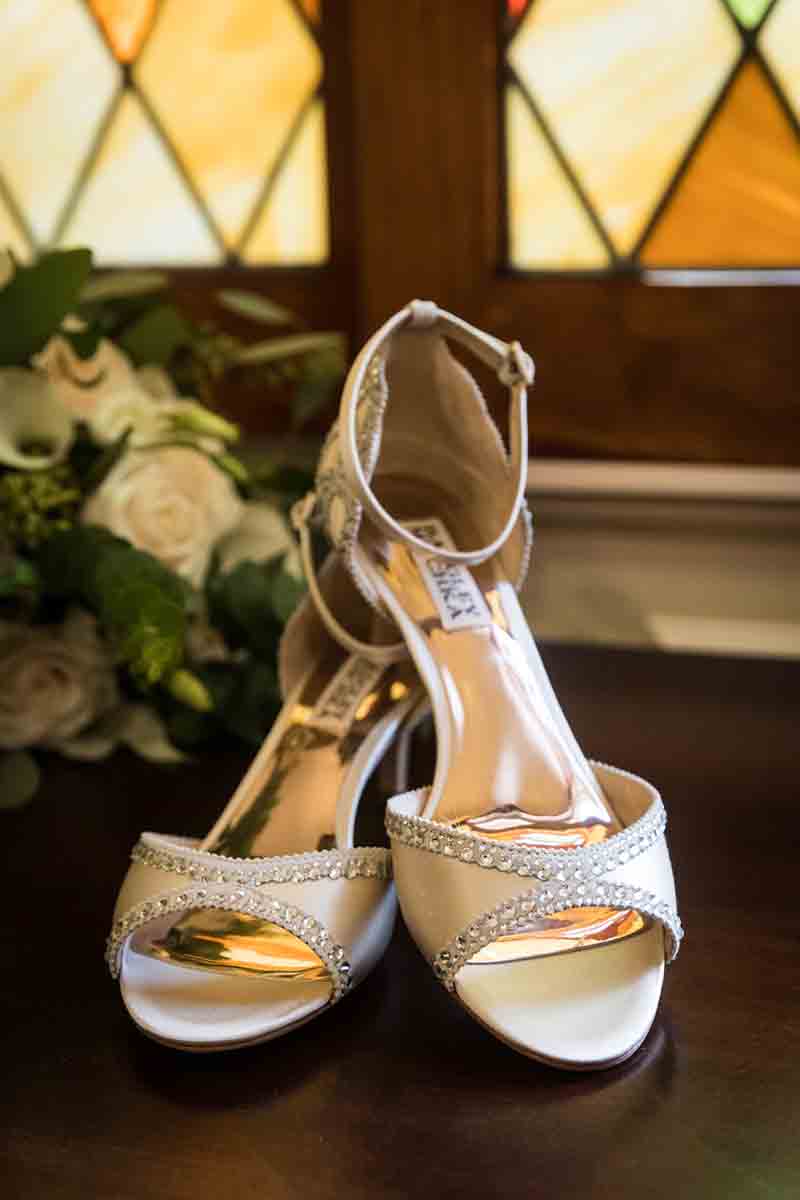 Badgley Mischka wedding heels on table with flower bouquet