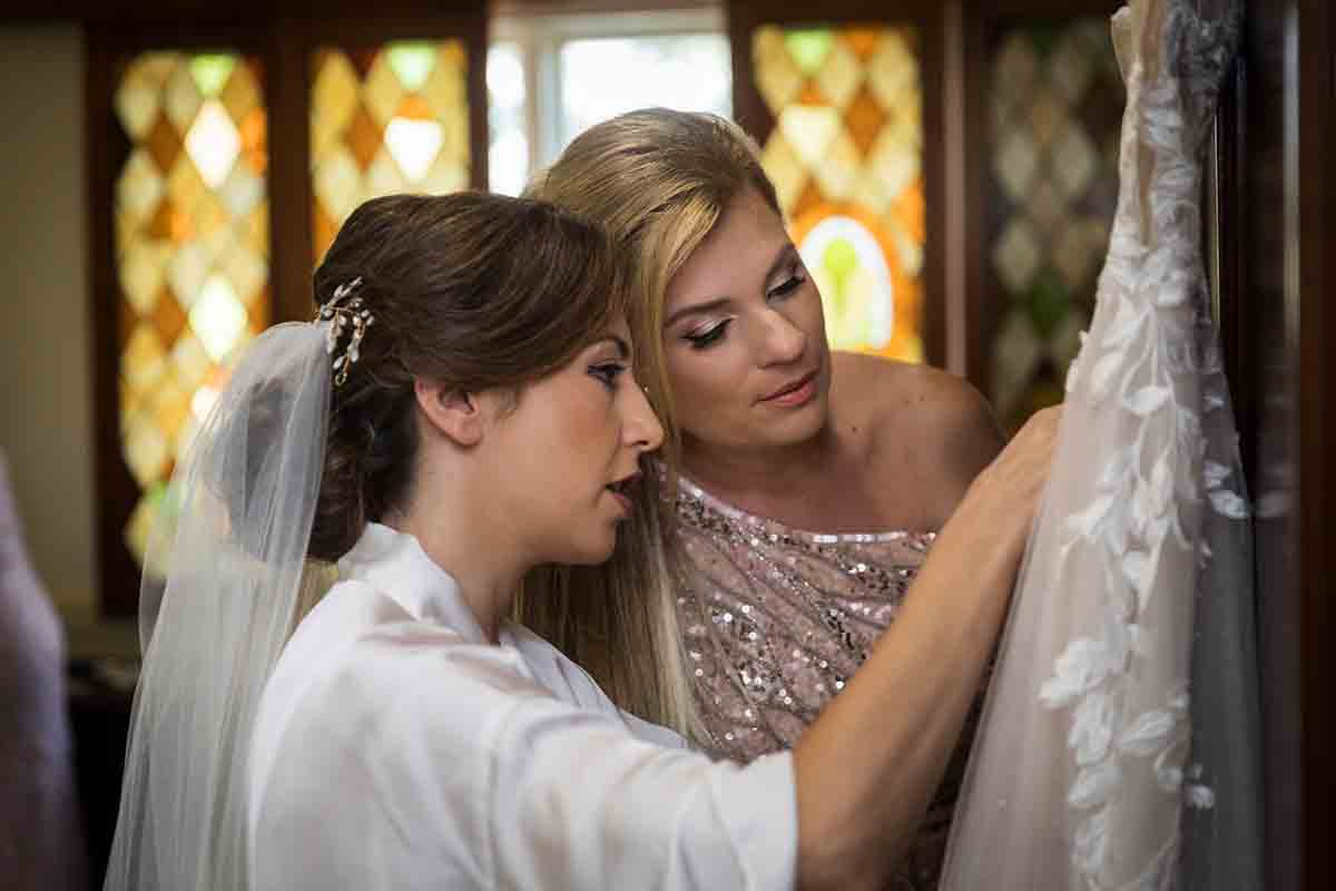 Bride and aunt looking at wedding dress