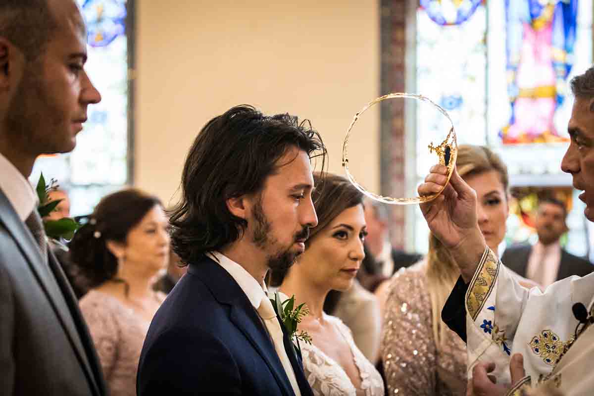 Bride and groom receiving crowns during eastern orthodox wedding ceremony