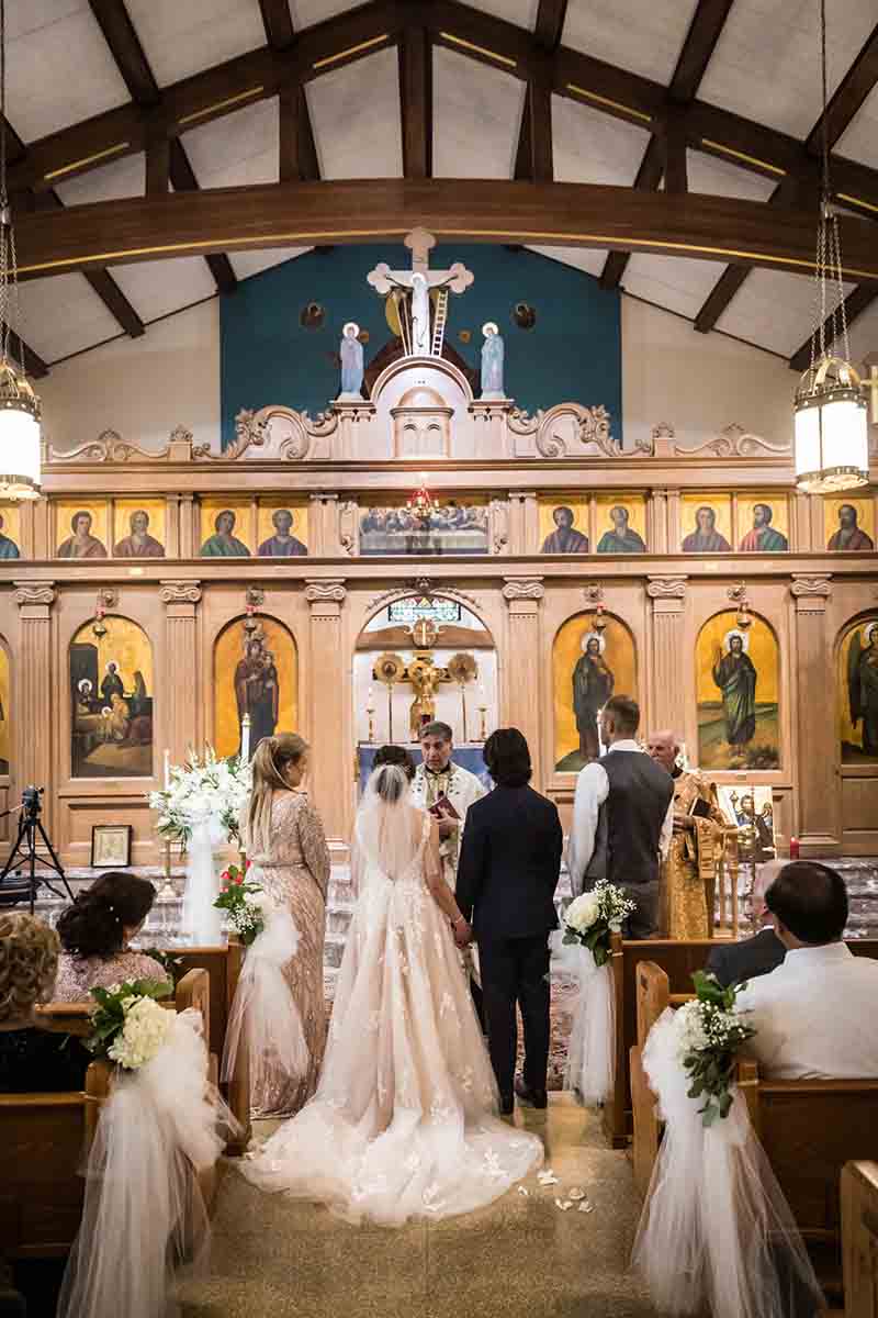 Bride and groom in front of altar during eastern orthodox wedding ceremony