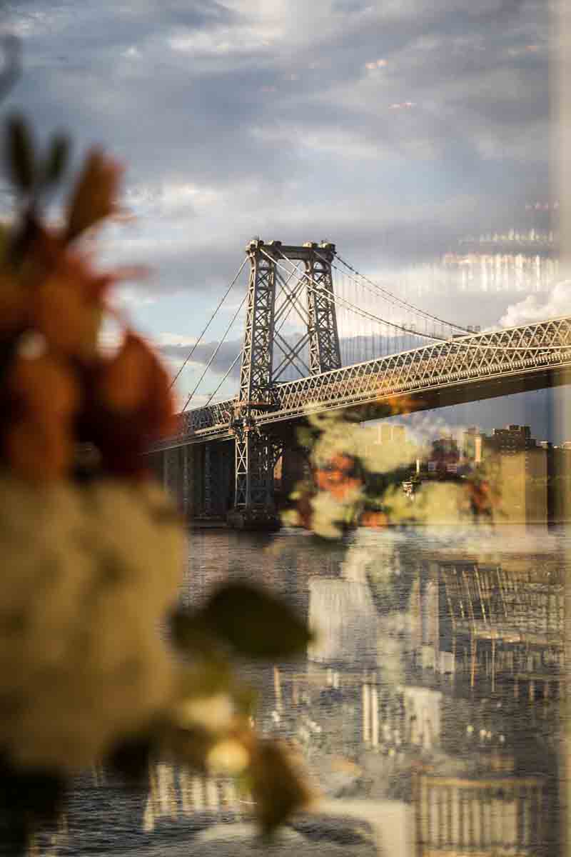 Williamsburg Bridge with reflection of ballroom at Giando on the Water reflected in window