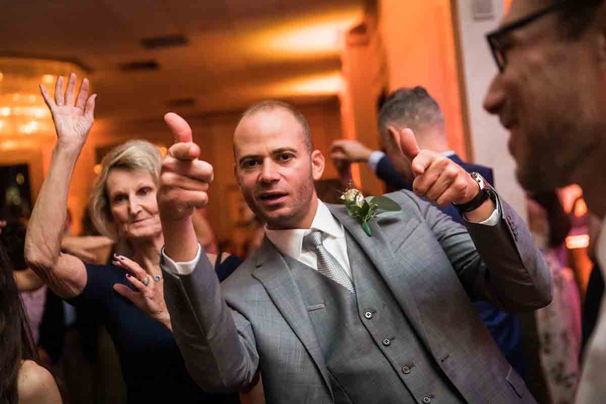 Male guest pointing at camera at a Giando on the Water wedding