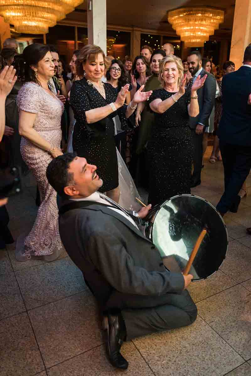 Male guest playing drum at a Giando on the Water wedding
