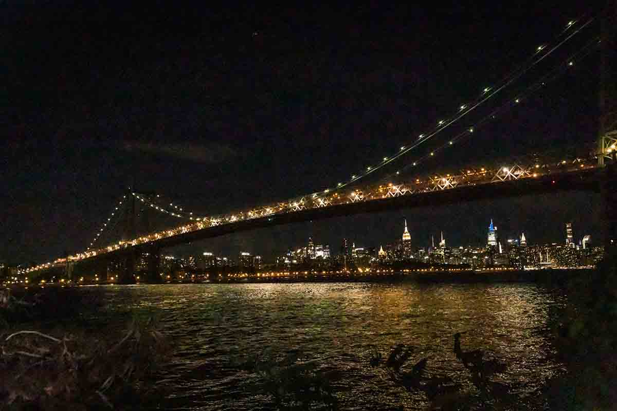 NYC bridge lit up at night