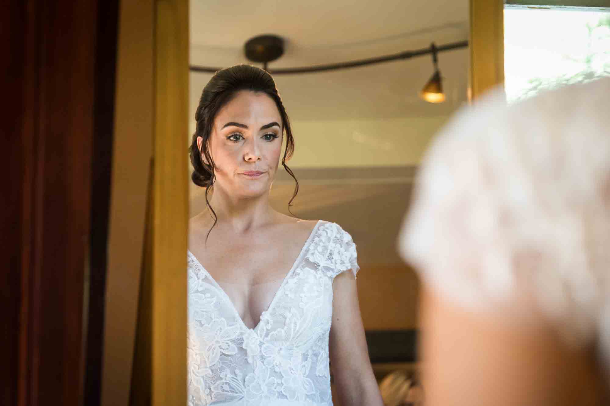 Bride looking into mirror at a FEAST at Round Hill wedding