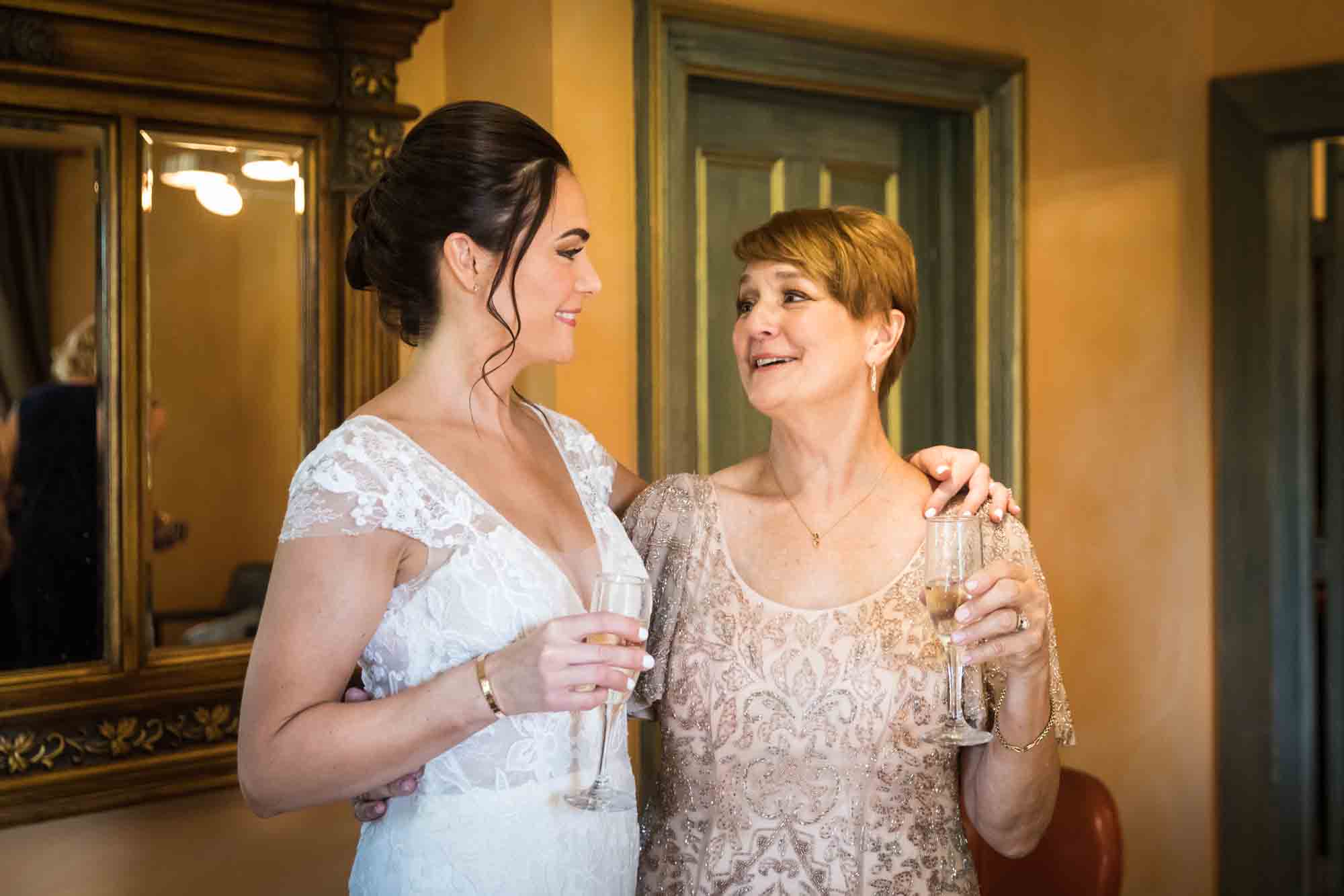 Bride and mother holding champagne glasses at a FEAST at Round Hill wedding