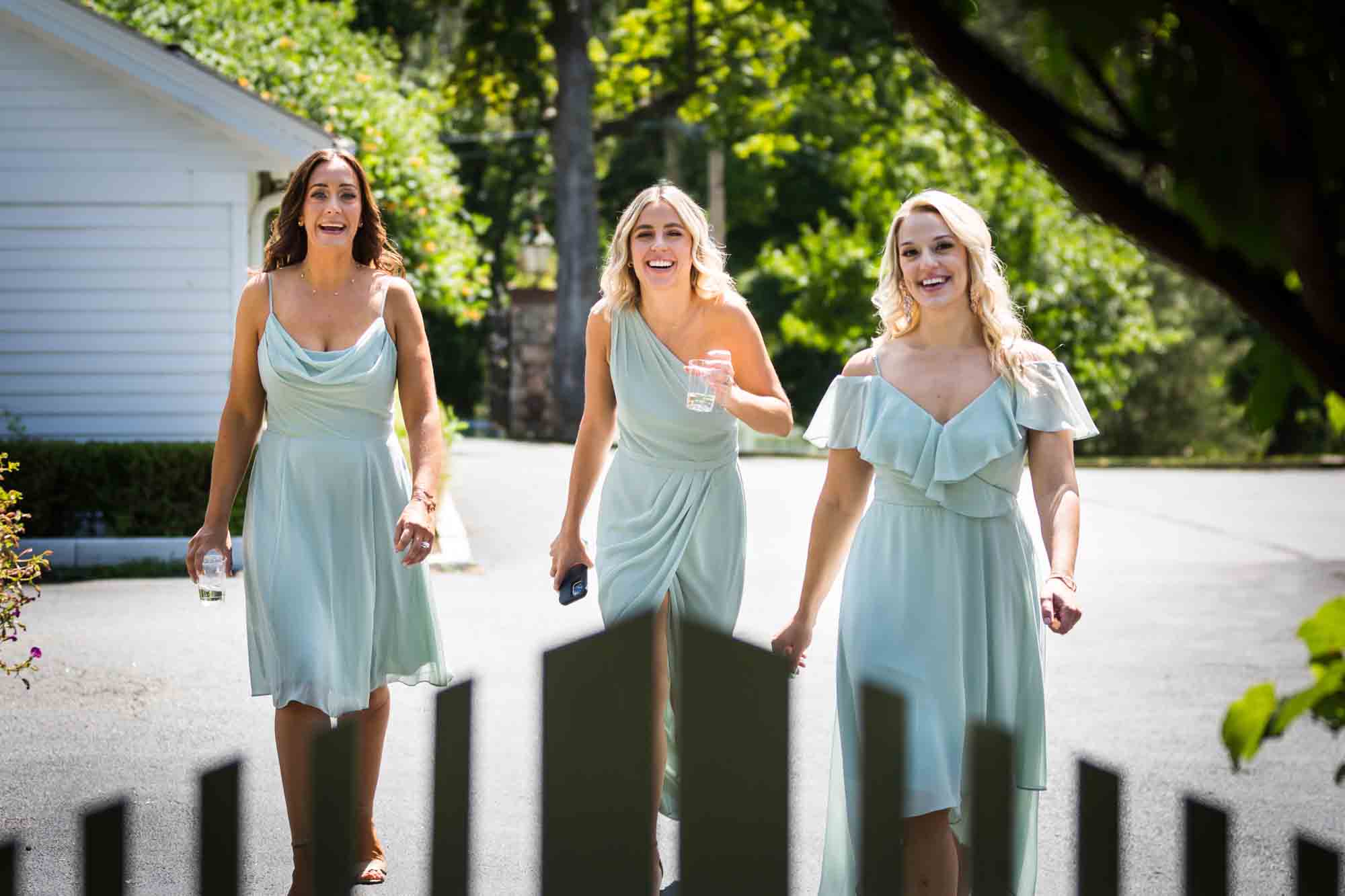 Three bridesmaids approaching gate at a FEAST at Round Hill wedding