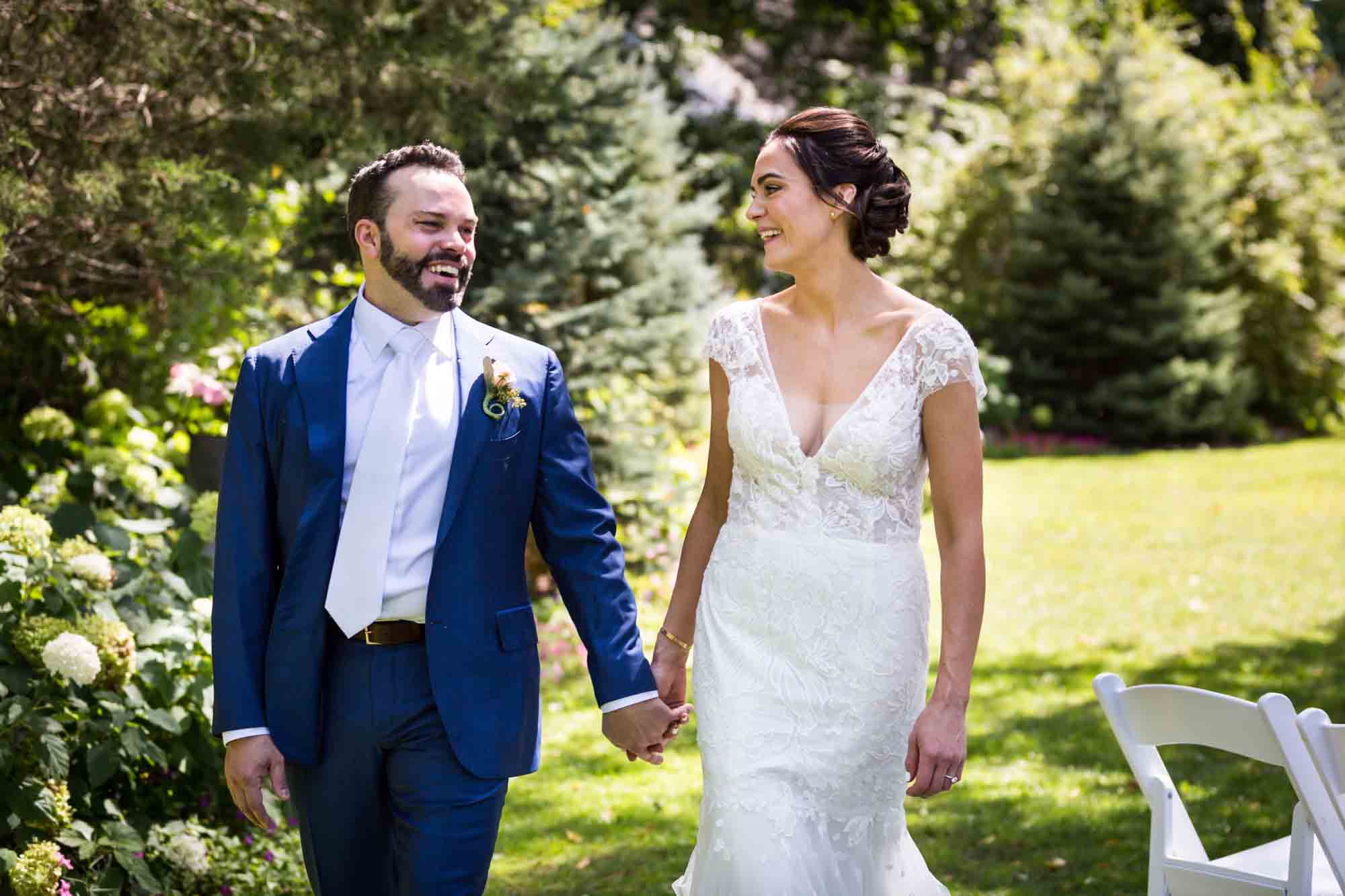 Bride and groom walking in garden for an article on how to relax in front of the camera