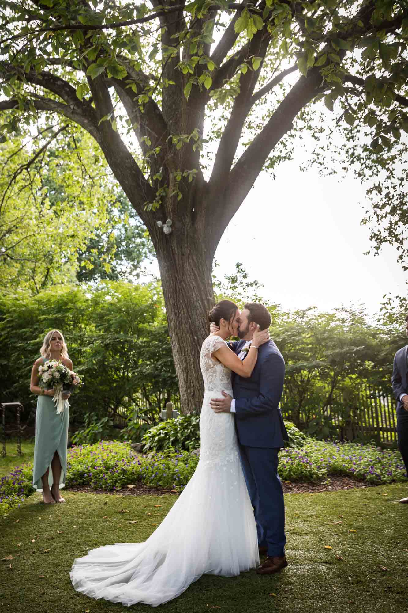 FEAST at Round Hill wedding photos of bride and groom kissing in garden ceremony