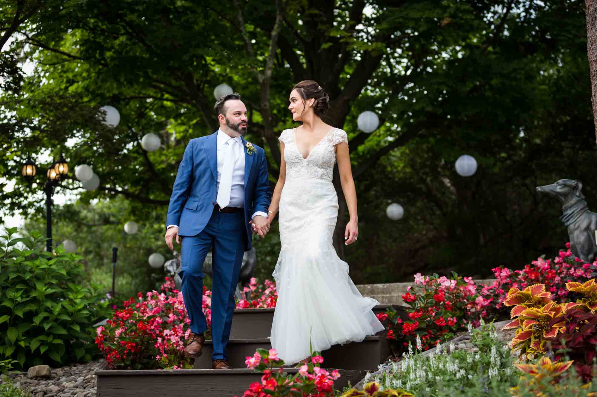 Bride and groom walking down steps in a garden for an article on how to relax in front of the camera