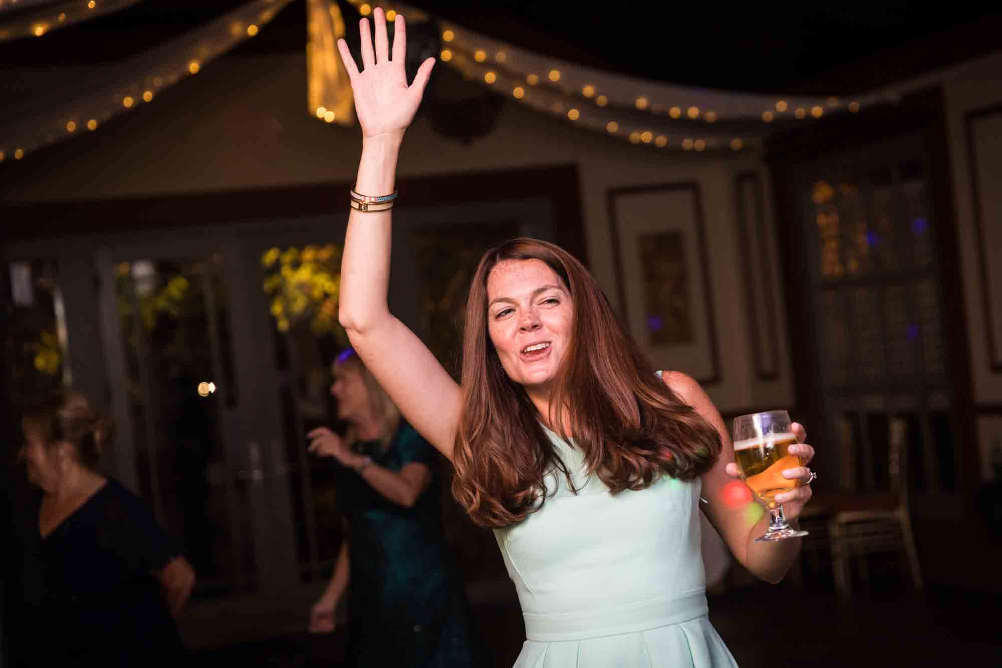 FEAST at Round Hill wedding photos of female guest dancing with arm in the air