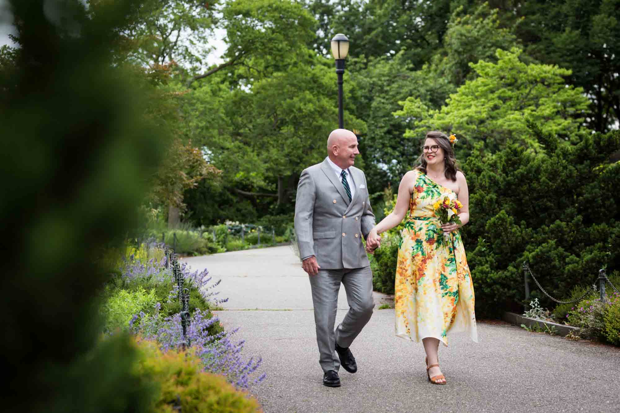 Bride and father walking on garden pathway for an article on how to select a wedding date