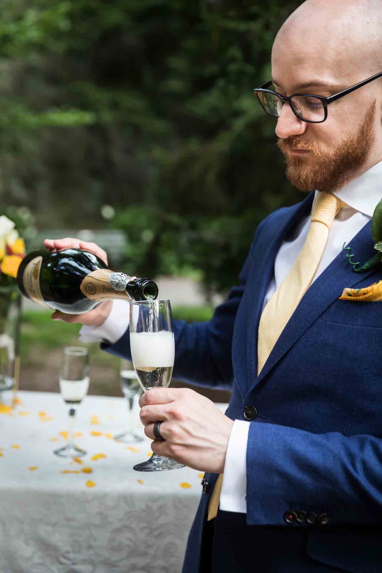 Groom pouring a glass of champagne for an article on how to select a wedding date