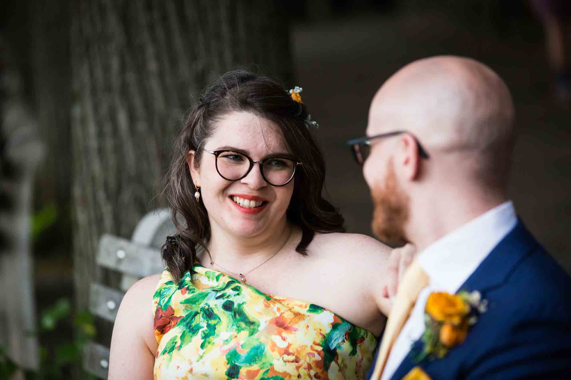 Fort Tryon wedding photos of bride looking at groom on bench